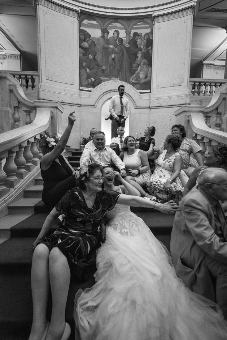 People seated on nottingham council house grand staircase laughing with each other during a wedding reception.