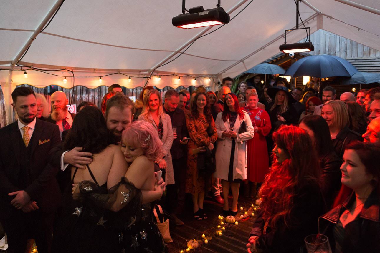 friends embrace during wedding ceremony at Beartown Tap pub beer garden