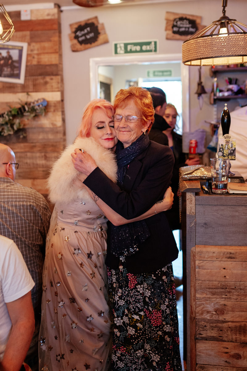 Two people share a warm hug in a cozy bar The Blues Dawg.