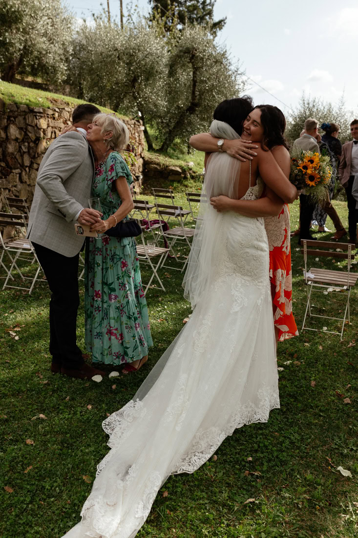 bride and groom hugging guests on the lawn